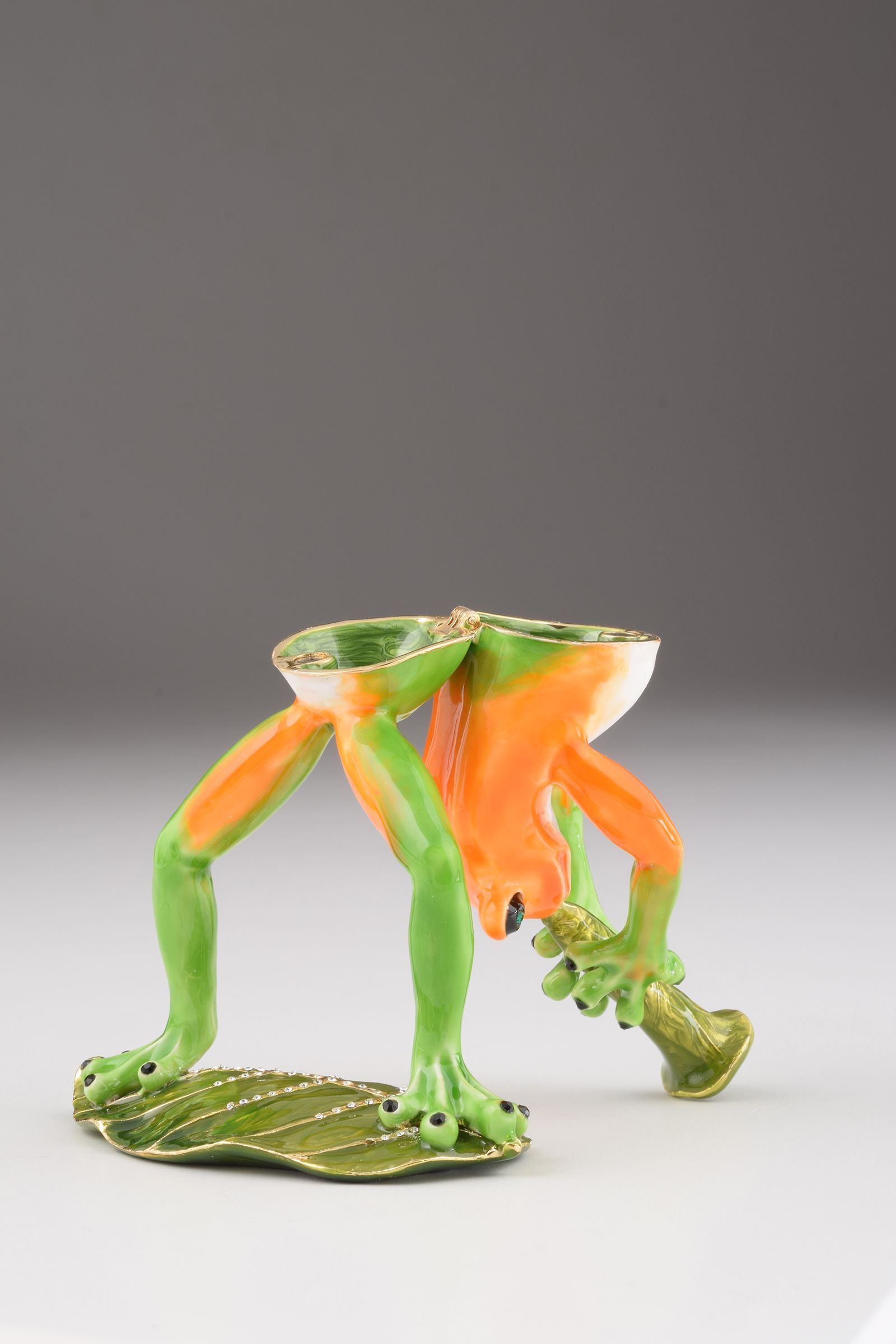 A beautifully crafted Trumpet Playing Frog trinket box, featuring vibrant enamel and sparkling Austrian crystals, plated with 24K gold.