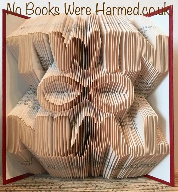 Handcrafted Infinity symbol art made from vintage book pages, showcasing intricate folds and unique textures.