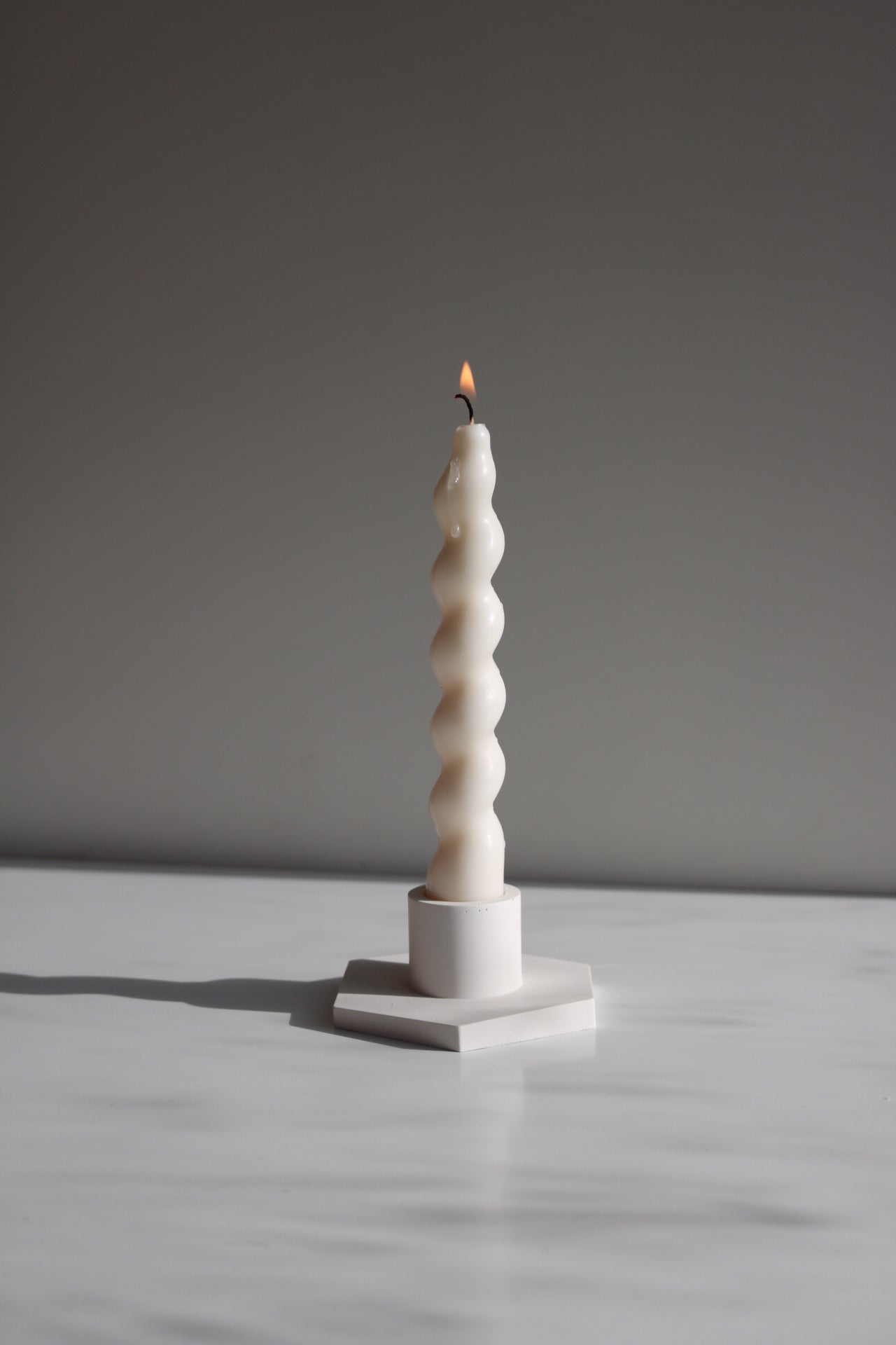 Elegant Twisted taper candle made from soy wax blend, showcasing its unique twisted design and neutral color.