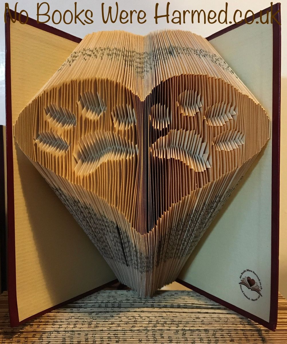 Handcrafted book art featuring two inverted paws within a heart, made from vintage book pages.