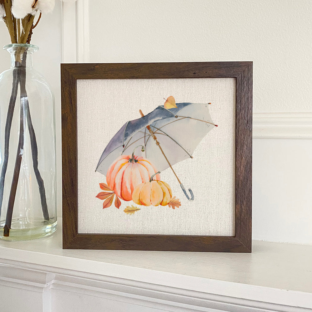 A beautifully framed sign featuring Umbrella Pumpkins design, set against a neutral linen-look background, perfect for autumn decor.