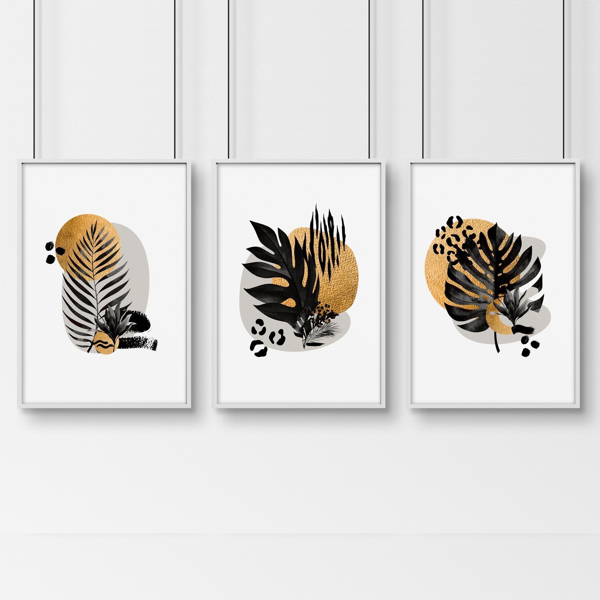 Set of 3 framed wall art prints featuring tropical botanical designs in gold, black, and grey, perfect for living room decor.