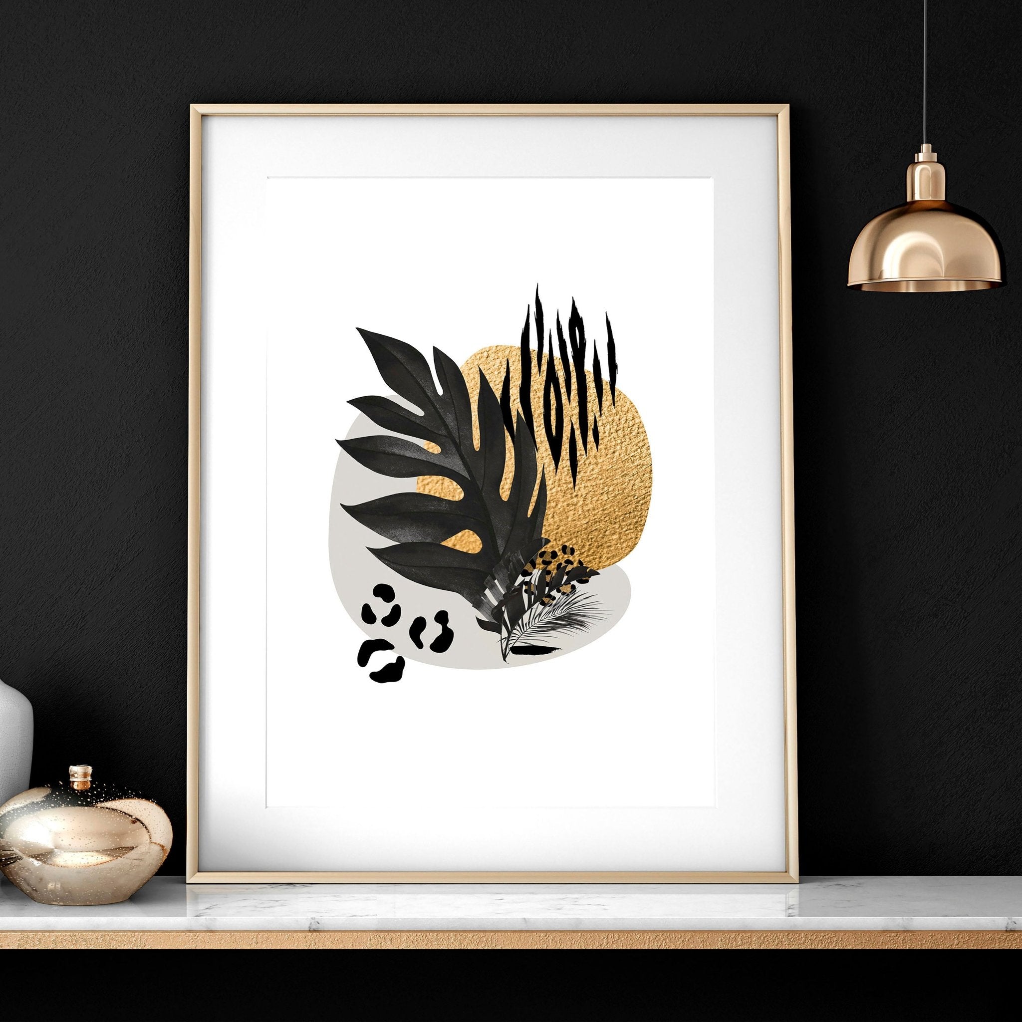 Set of 3 framed wall art prints featuring tropical botanical designs in gold, black, and grey, perfect for living room decor.