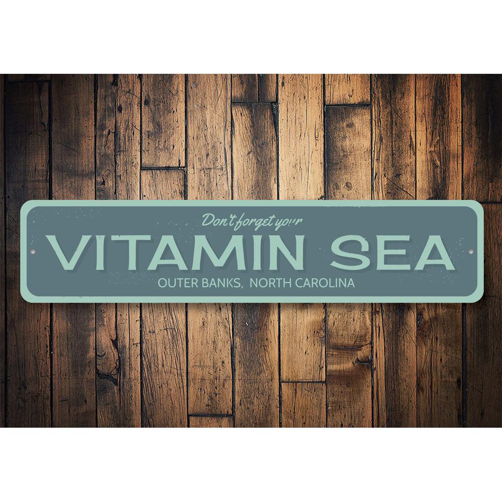 A decorative Vitamin Sea sign made of high-quality aluminum, featuring a beach-themed design, perfect for coastal decor.