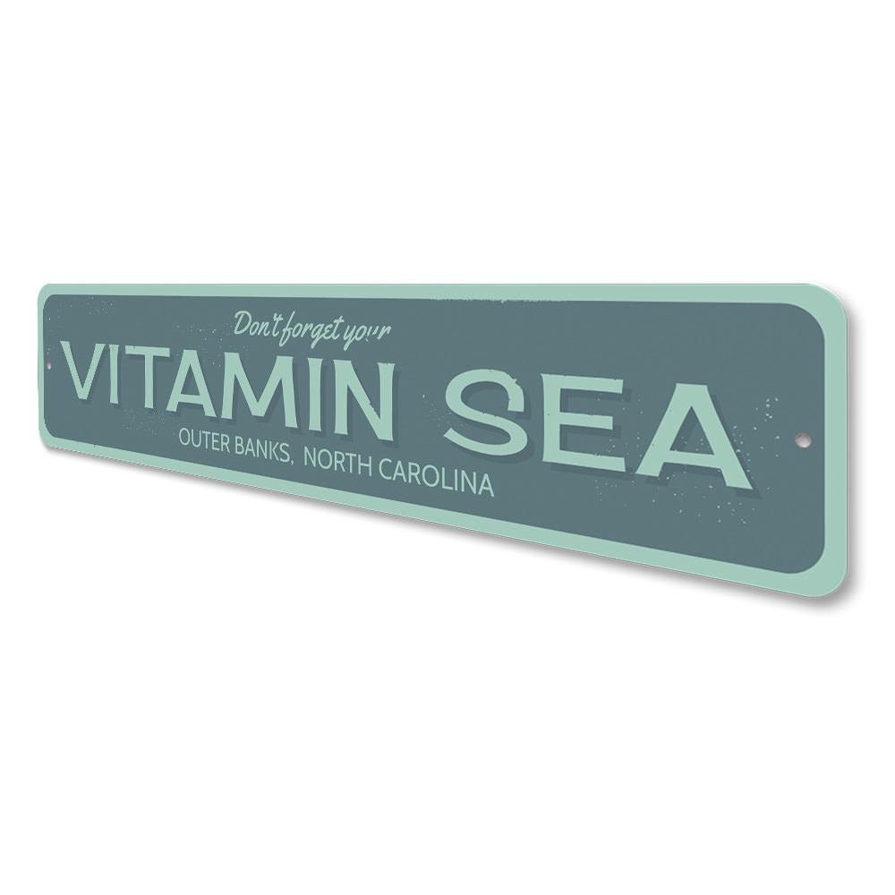 A decorative Vitamin Sea sign made of high-quality aluminum, featuring a beach-themed design, perfect for coastal decor.