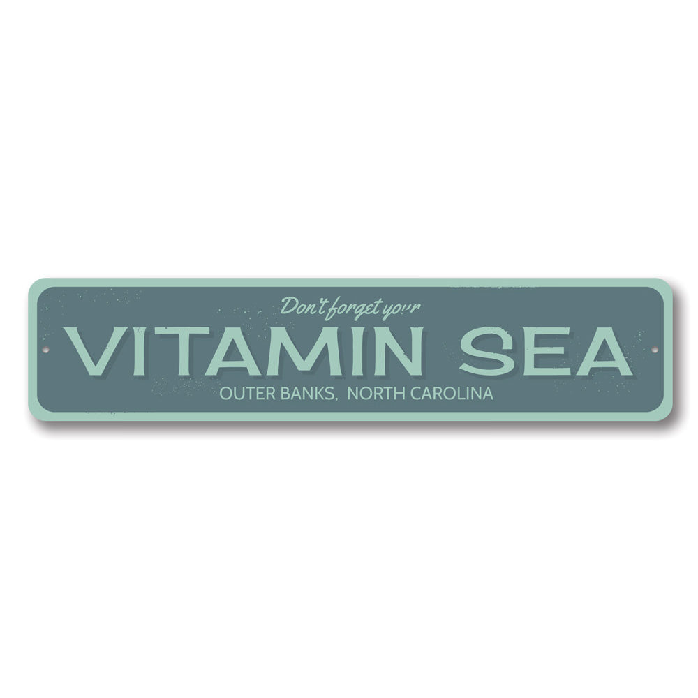 A decorative Vitamin Sea sign made of high-quality aluminum, featuring a beach-themed design, perfect for coastal decor.