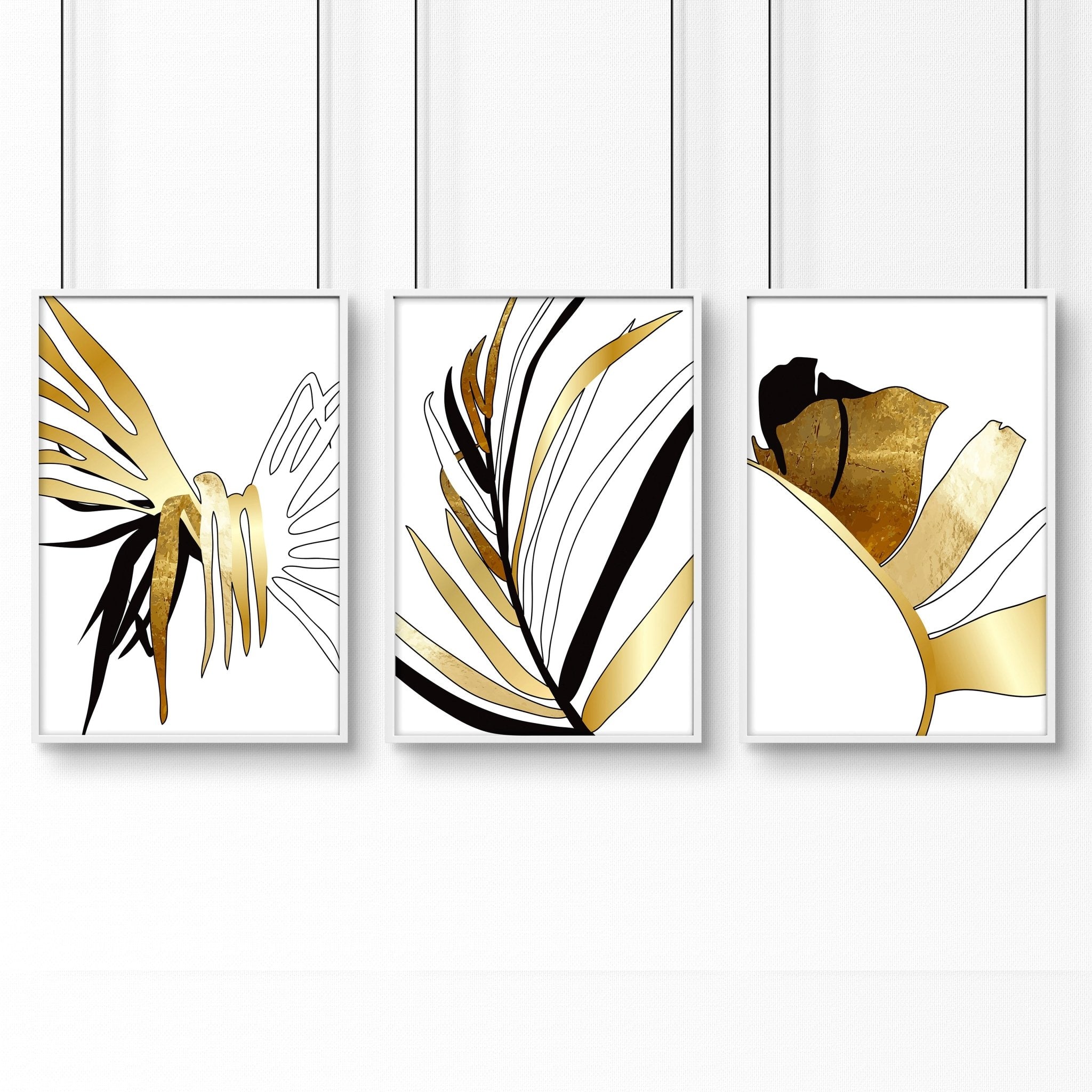 Set of 3 modern tropical wall art prints featuring elegant botanical designs in white, black, and gold, perfect for living room decor.