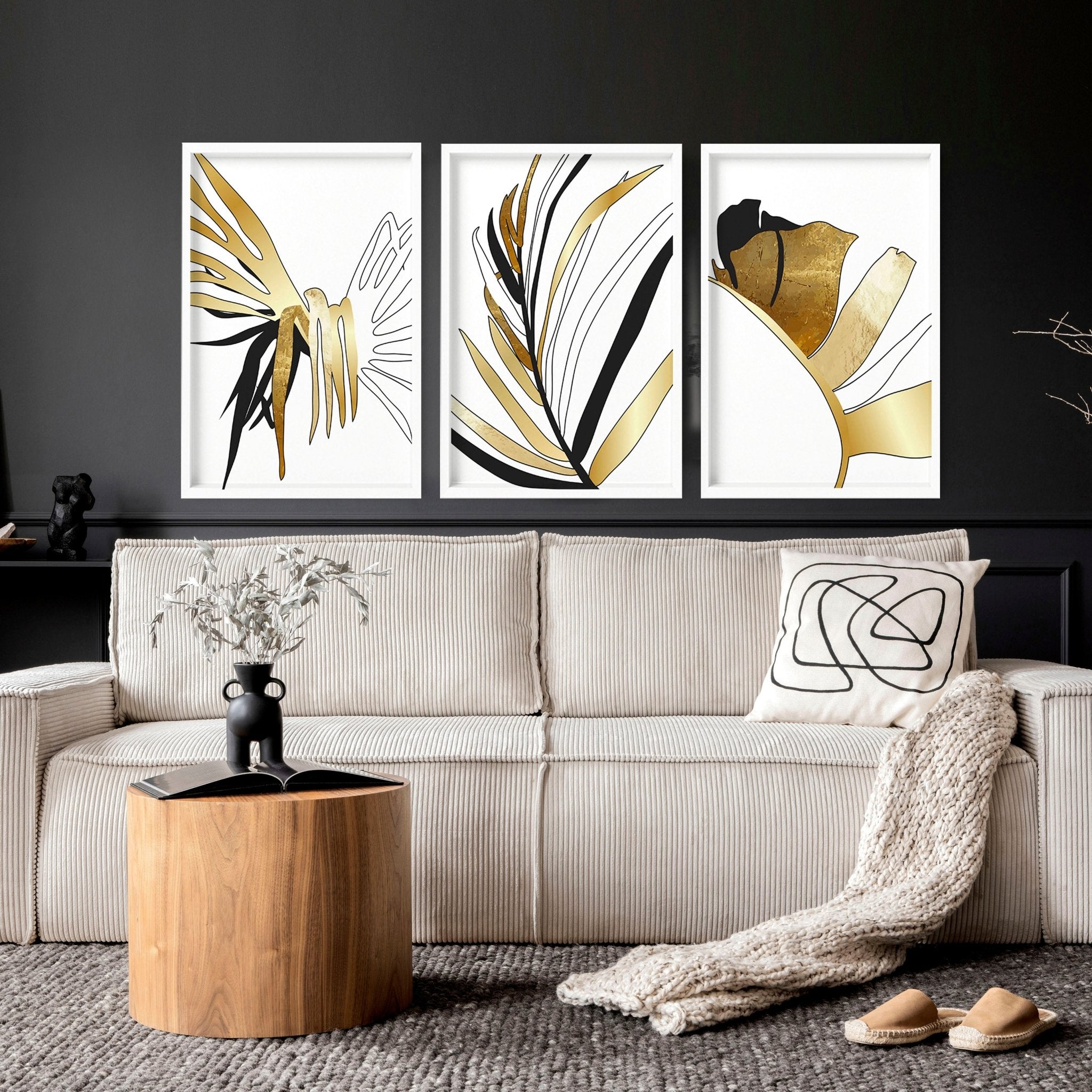 Set of 3 modern tropical wall art prints featuring elegant botanical designs in white, black, and gold, perfect for living room decor.