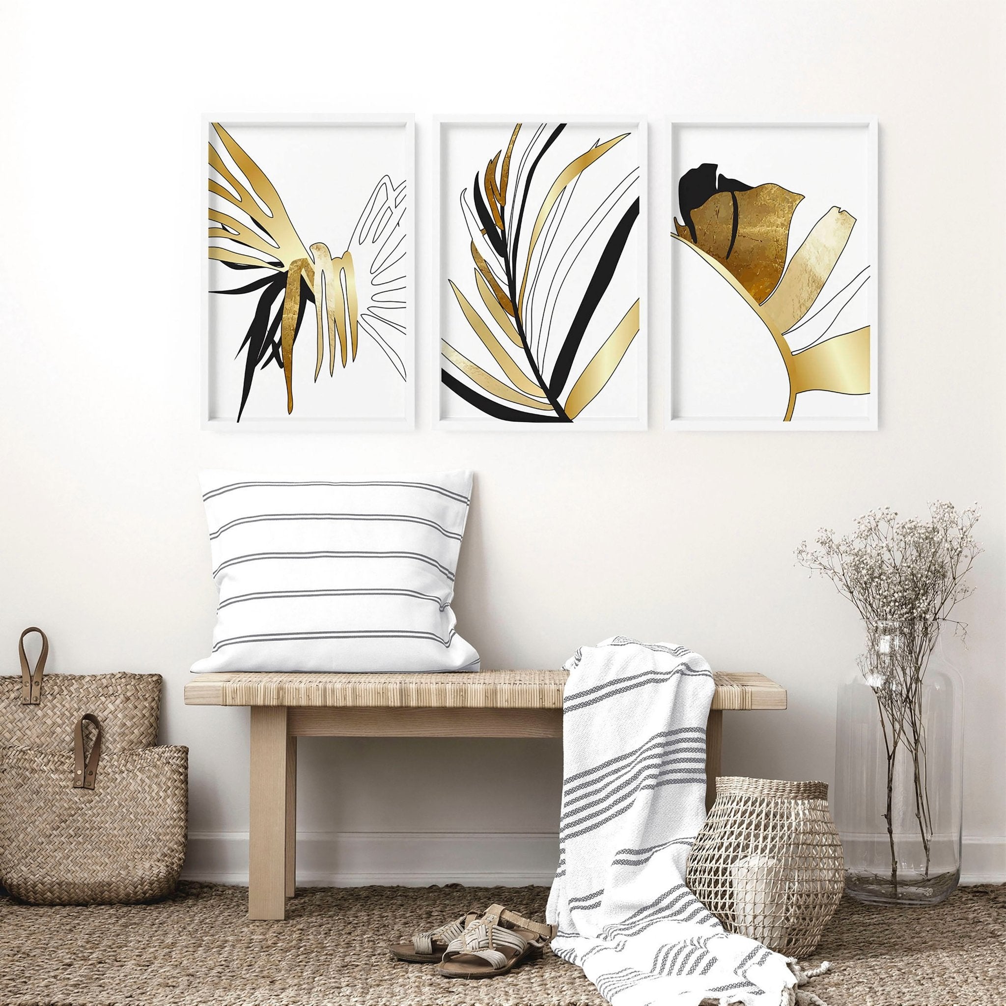 Set of 3 modern tropical wall art prints featuring elegant botanical designs in white, black, and gold, perfect for living room decor.