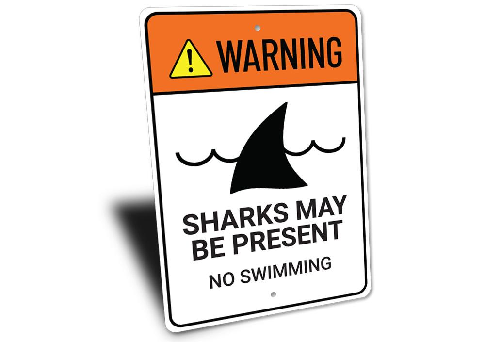 Warning Sharks Present Sign made of durable aluminum, featuring a vibrant beach-themed design, perfect for coastal decor.