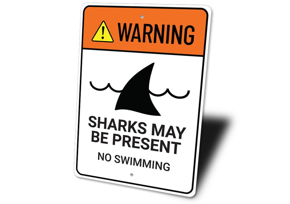 Warning Sharks Present Sign made of durable aluminum, featuring a vibrant beach-themed design, perfect for coastal decor.