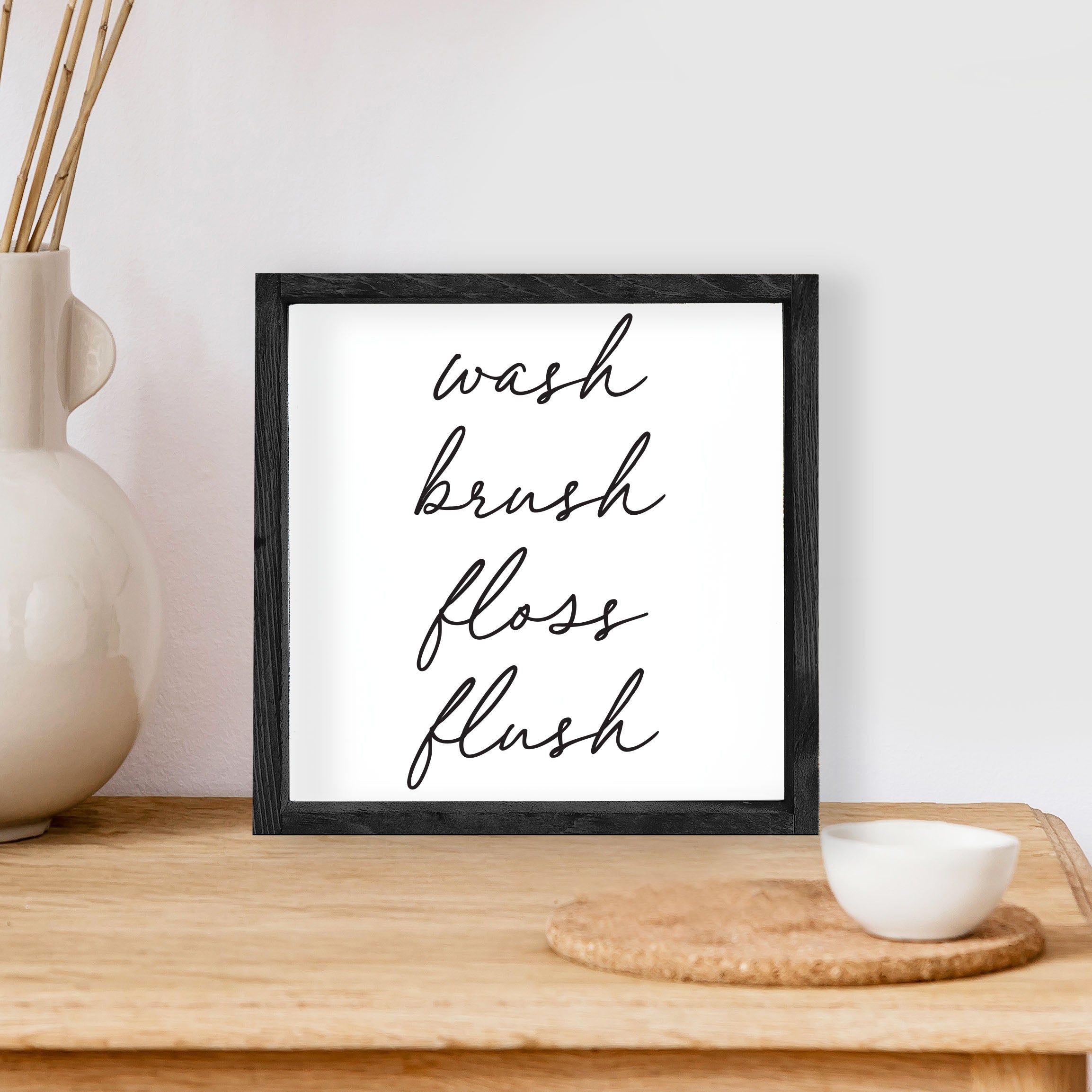 Wash Brush Floss Flush Wood Sign with a rustic wood frame and waterproof black text on a white background, measuring 8x8 inches.