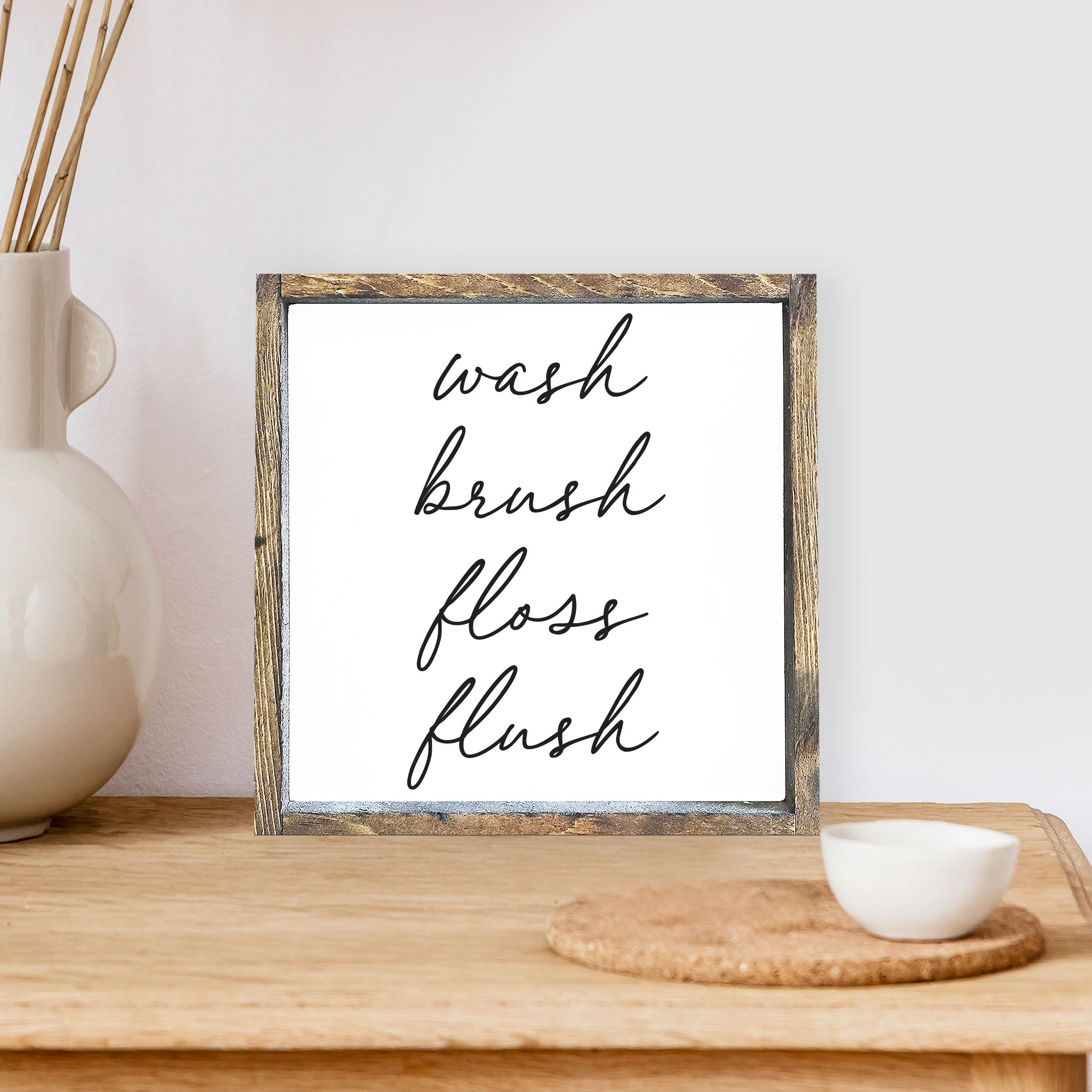 Wash Brush Floss Flush Wood Sign with a rustic wood frame and waterproof black text on a white background, measuring 8x8 inches.