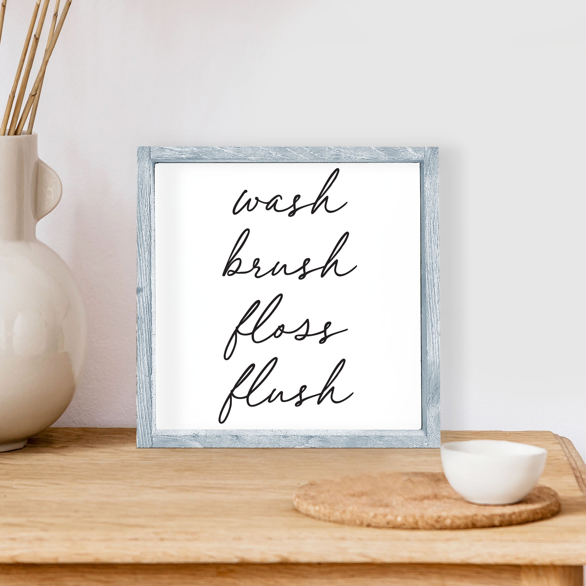 Wash Brush Floss Flush Wood Sign with a rustic wood frame and waterproof black text on a white background, measuring 8x8 inches.