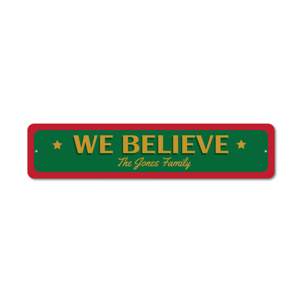 A festive 'We Believe Christmas' sign made of aluminum, featuring vibrant colors and a charming design, perfect for holiday decorations.