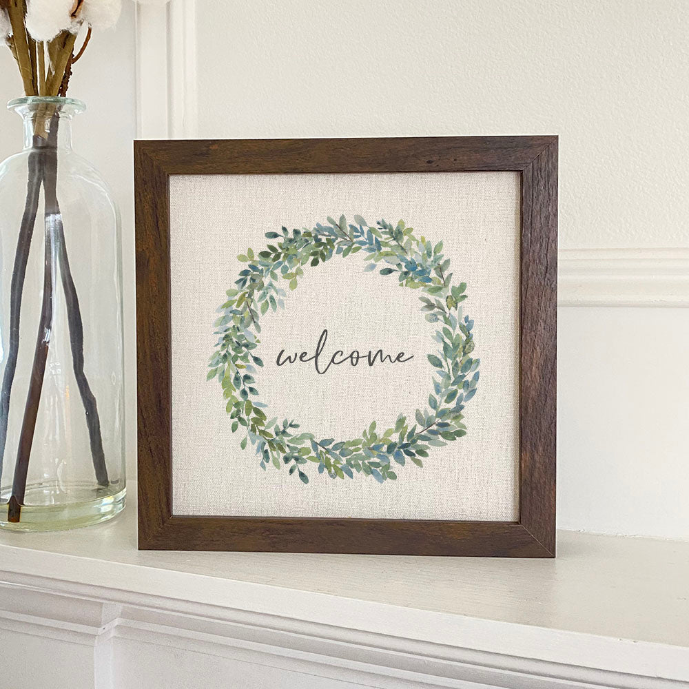 Welcome Boxwood Wreath framed sign with a stylized wood frame and linen-look background, perfect for home decor.