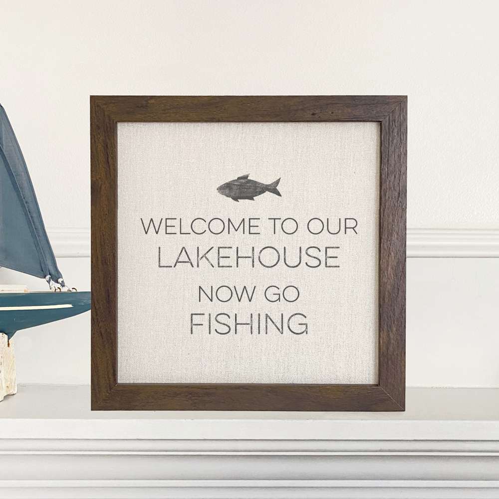 Welcome Lakehouse framed sign featuring a fish design, with a natural wood frame and linen-look background.