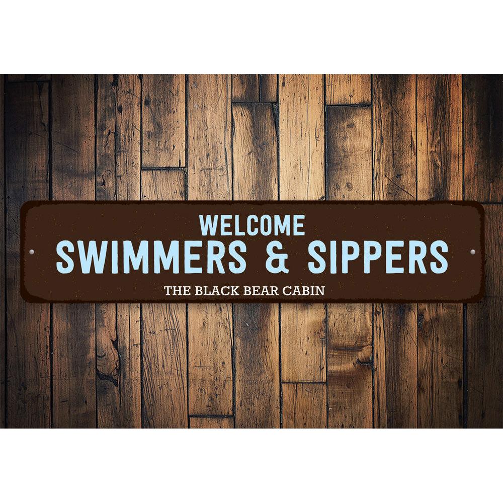 Welcome Swimmers & Sippers Sign made of durable aluminum, featuring a charming design perfect for lakehouses.