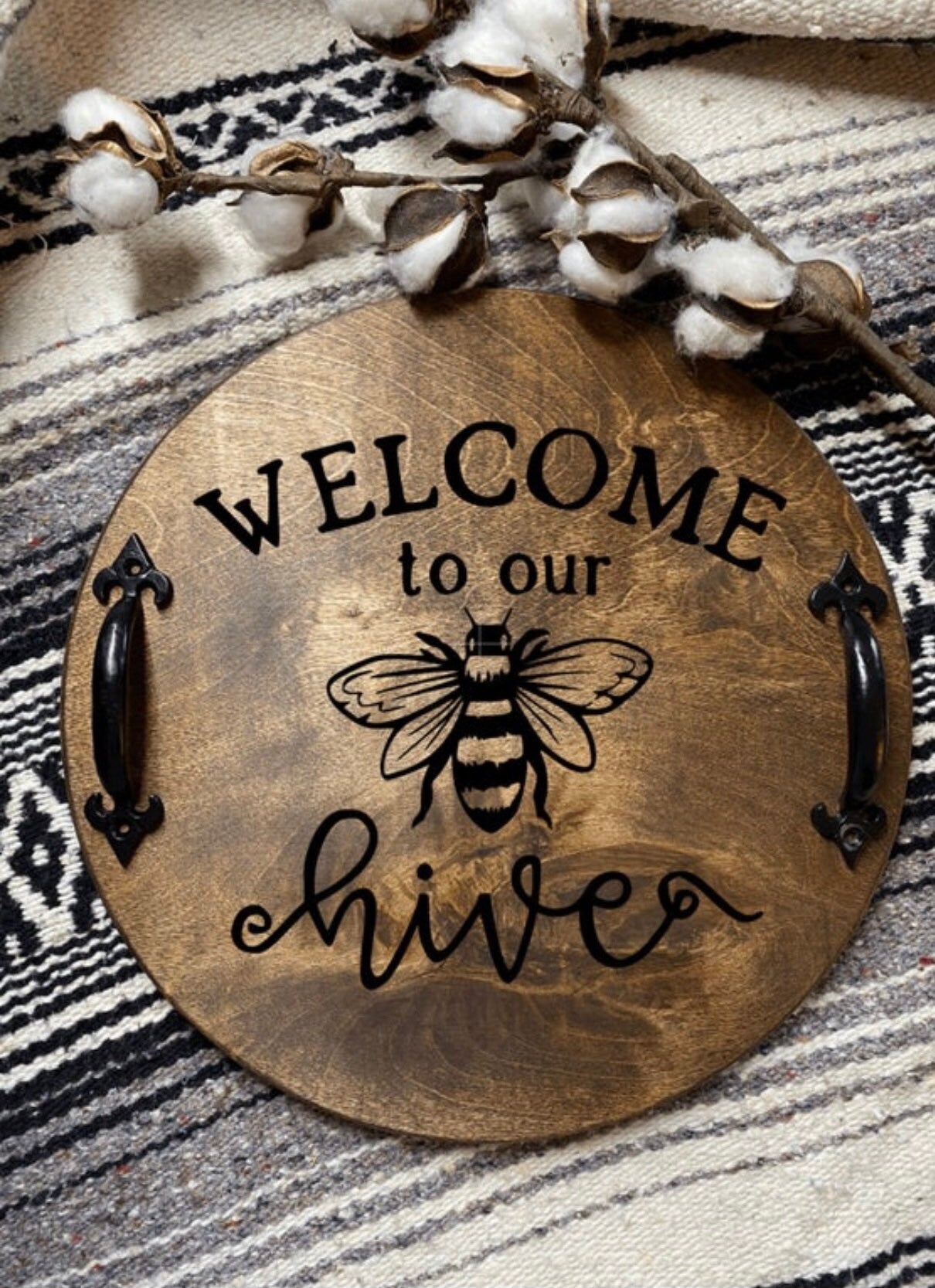 Handmade wooden serving tray with dark chestnut stain and black metal handles, featuring the phrase 'Welcome to our Hive' burned into the wood.