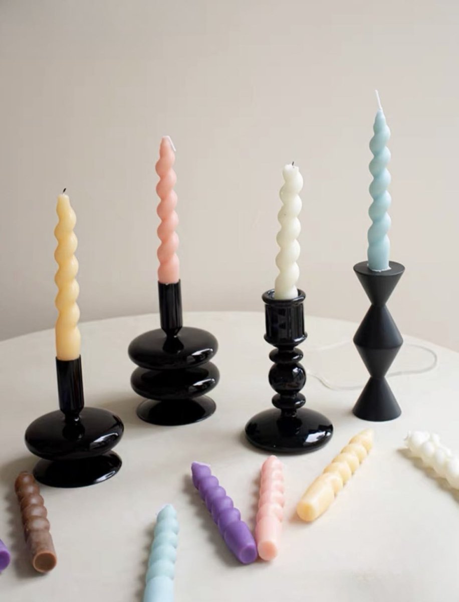 A colorful set of 7 whimsical twisty soy wax decorative candles arranged artistically, showcasing their unique shapes and vibrant colors.