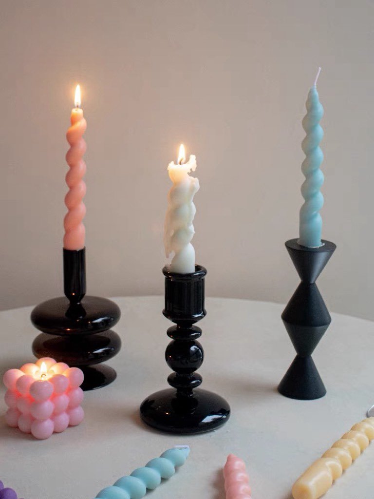 A colorful set of 7 whimsical twisty soy wax decorative candles arranged artistically, showcasing their unique shapes and vibrant colors.