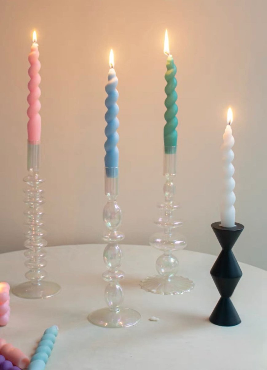 A colorful set of 7 whimsical twisty soy wax decorative candles arranged artistically, showcasing their unique shapes and vibrant colors.