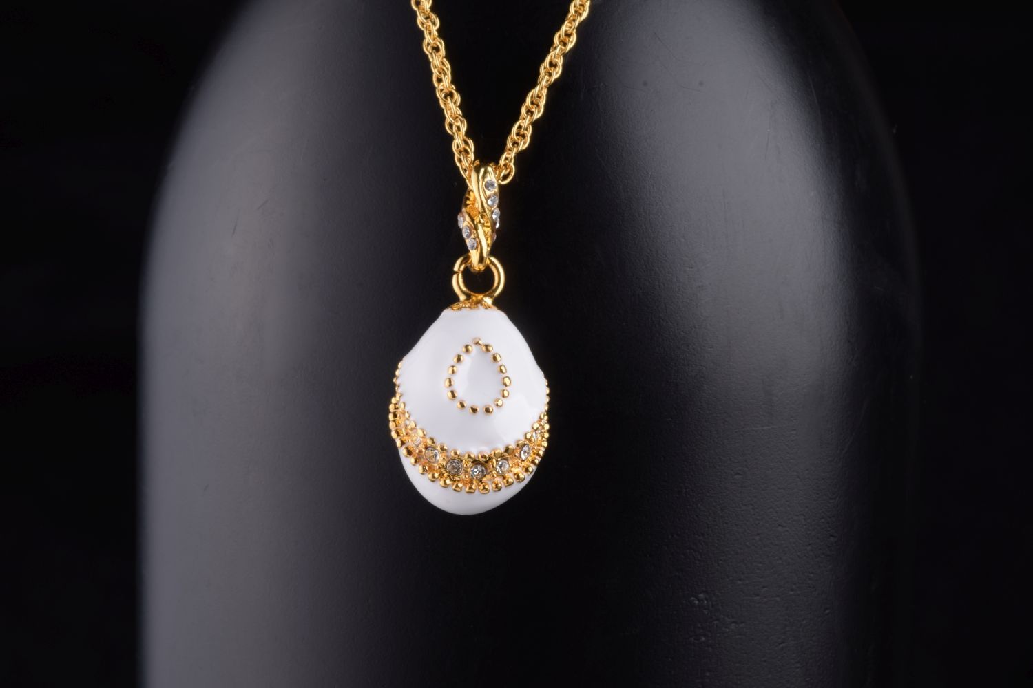 Elegant White Egg Pendant Necklace with hand-painted enamel and Austrian crystals, plated with 24K gold, displayed on a soft background.