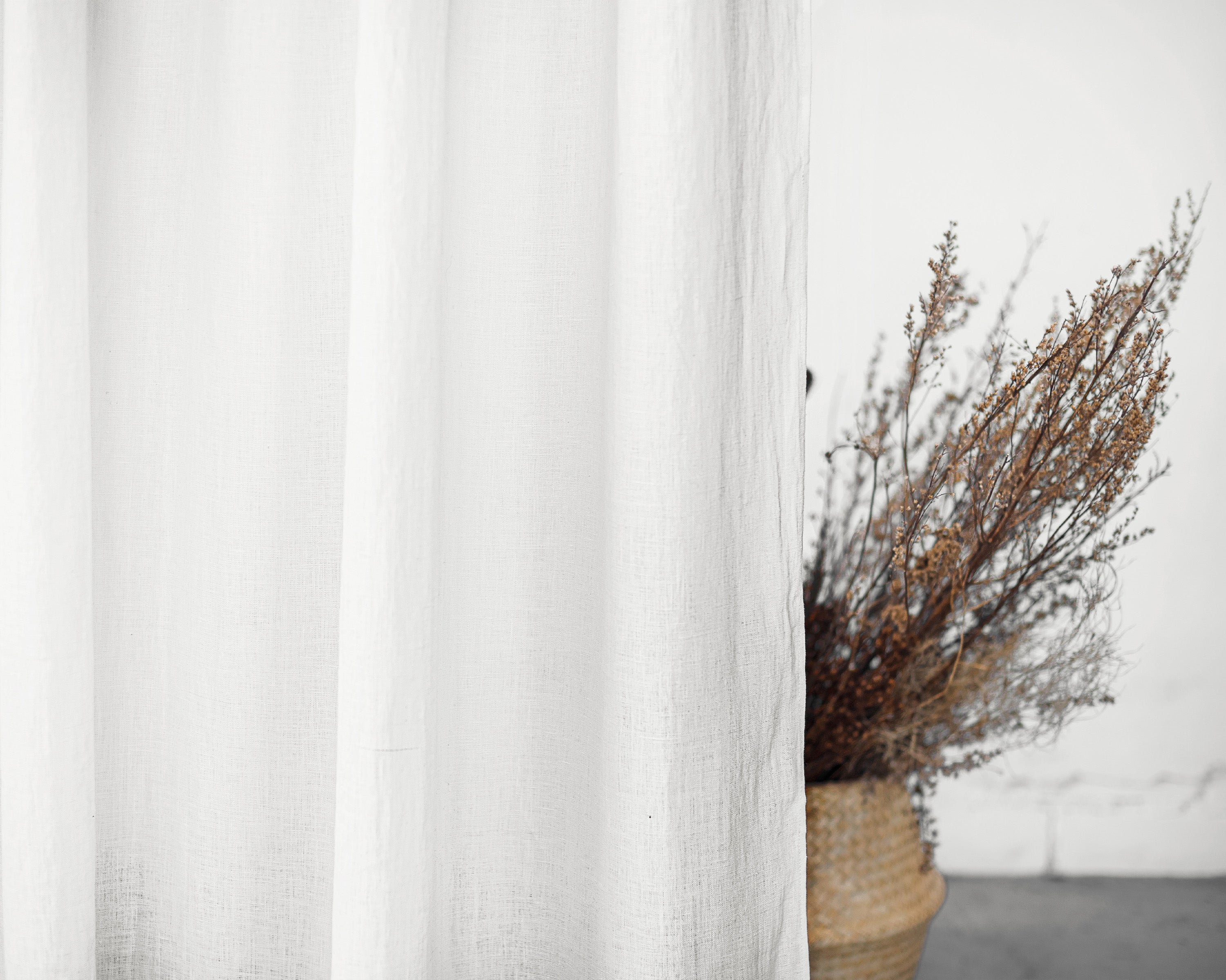 Elegant white linen curtain with tab tops, showcasing a semi-sheer texture and soft draping, perfect for enhancing home decor.