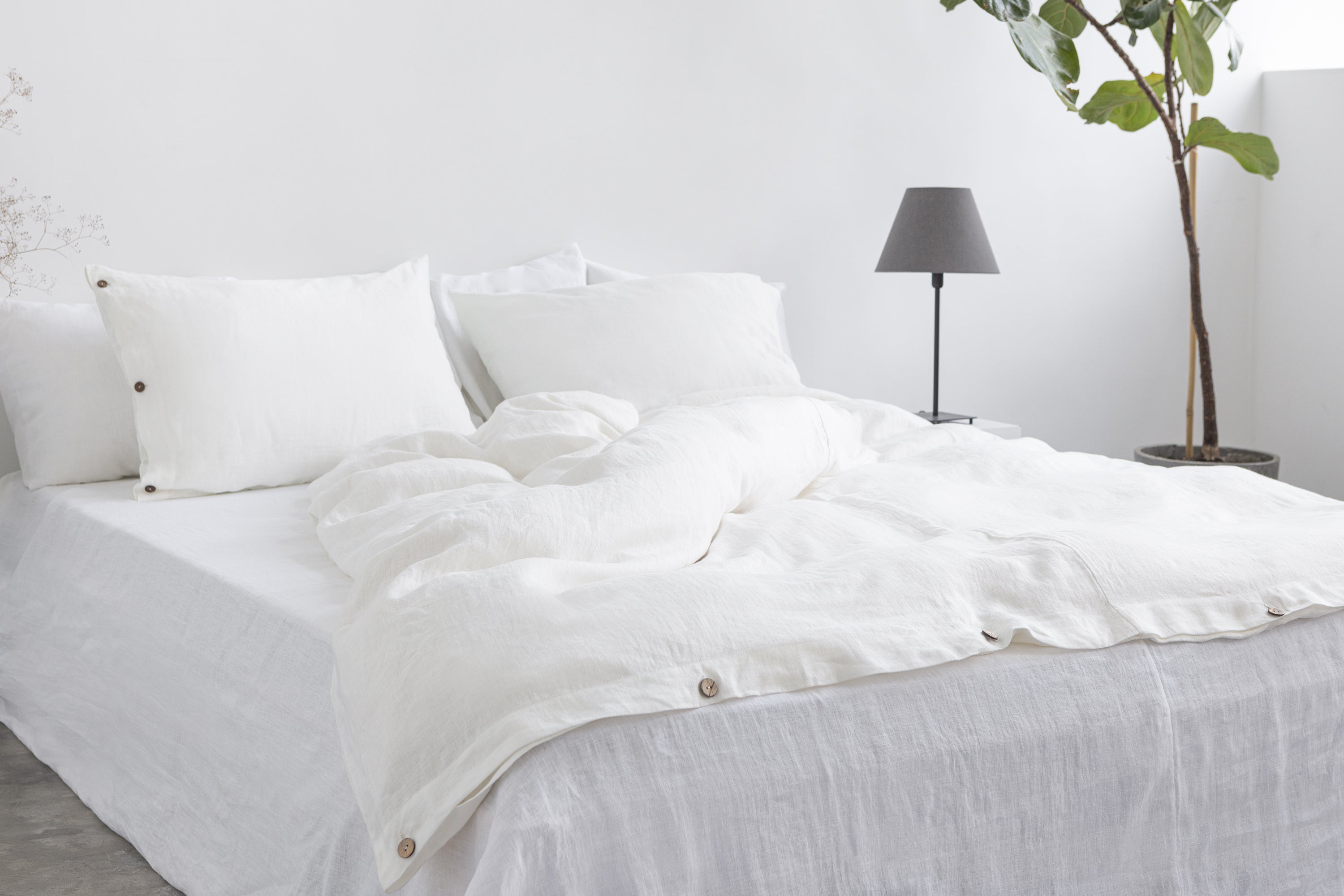 A luxurious white linen duvet cover featuring coconut buttons, showcasing its soft texture and elegant design.