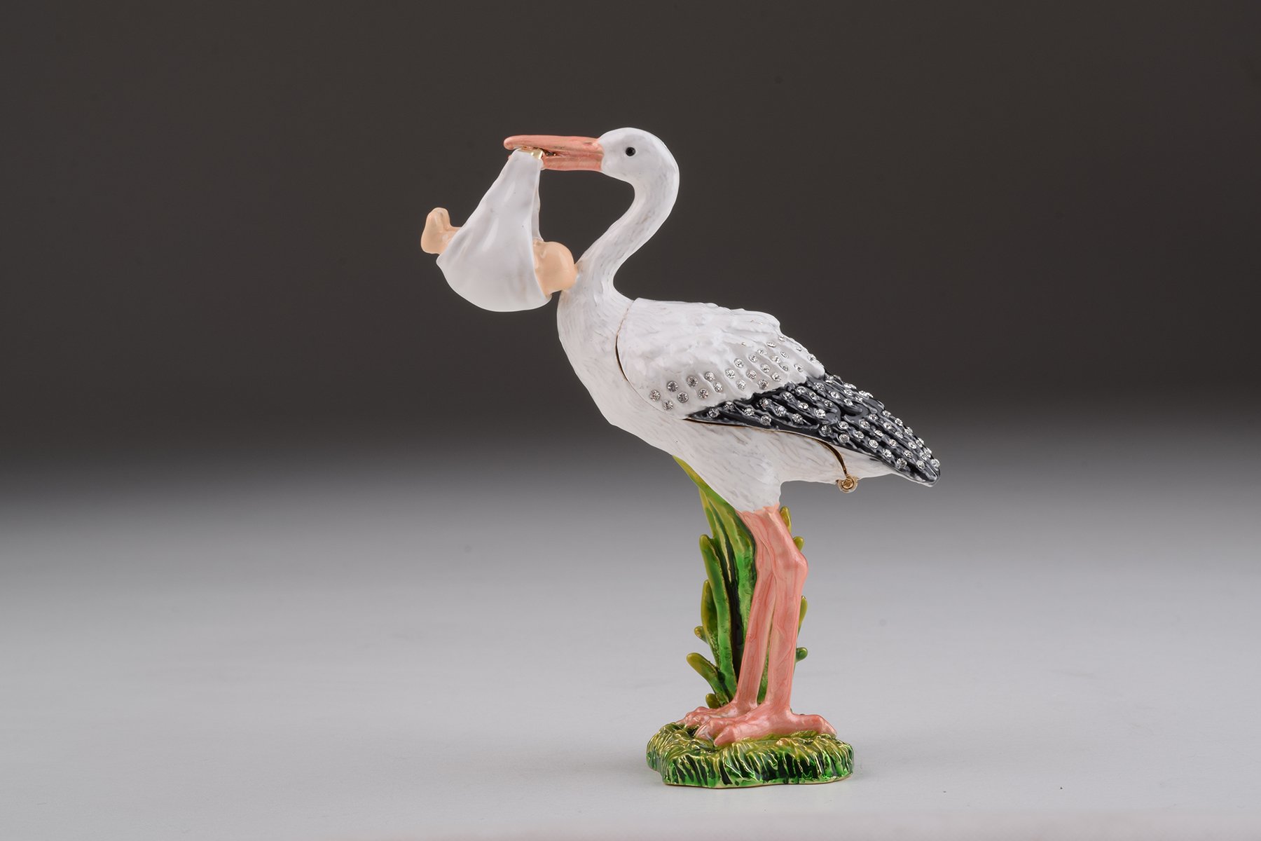 Handcrafted White Stork Carrying a Baby trinket box adorned with Austrian crystals and plated with 24K gold, showcasing exquisite craftsmanship.