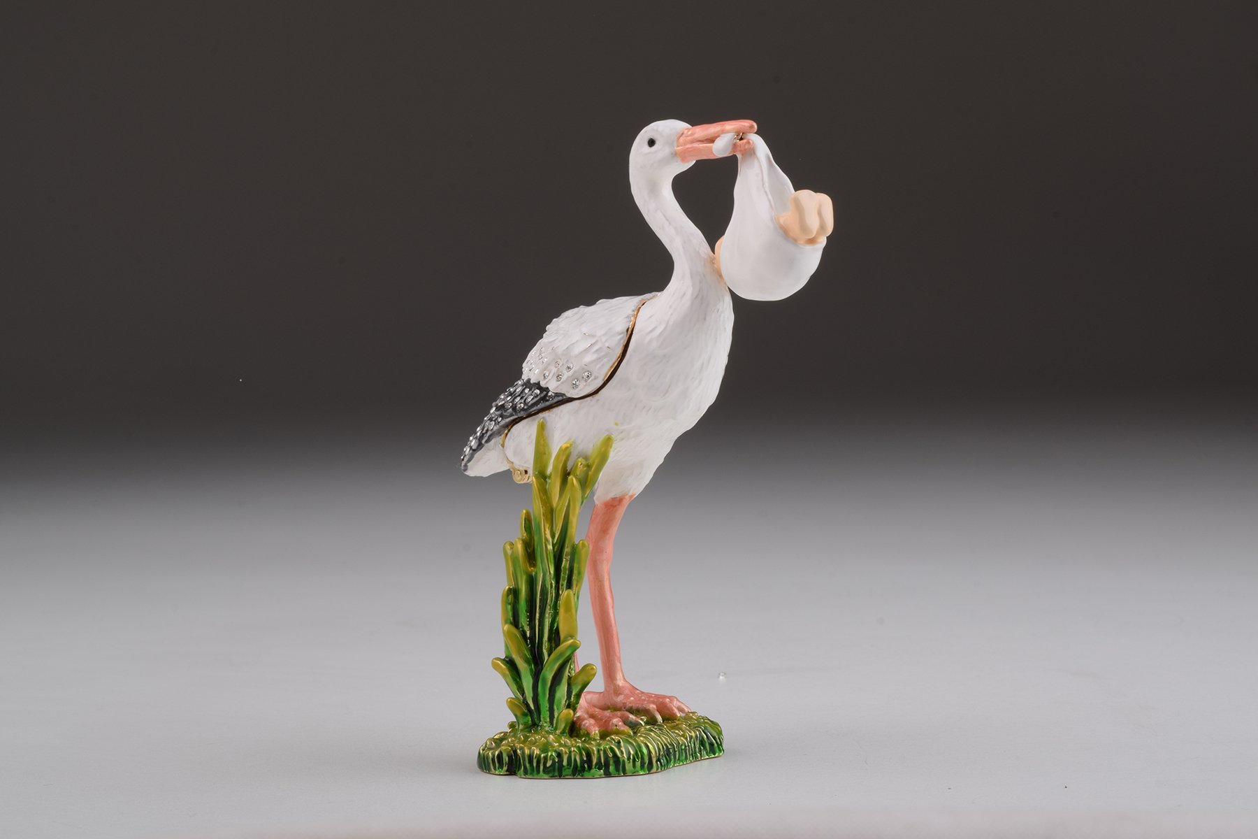 Handcrafted White Stork Carrying a Baby trinket box adorned with Austrian crystals and plated with 24K gold, showcasing exquisite craftsmanship.