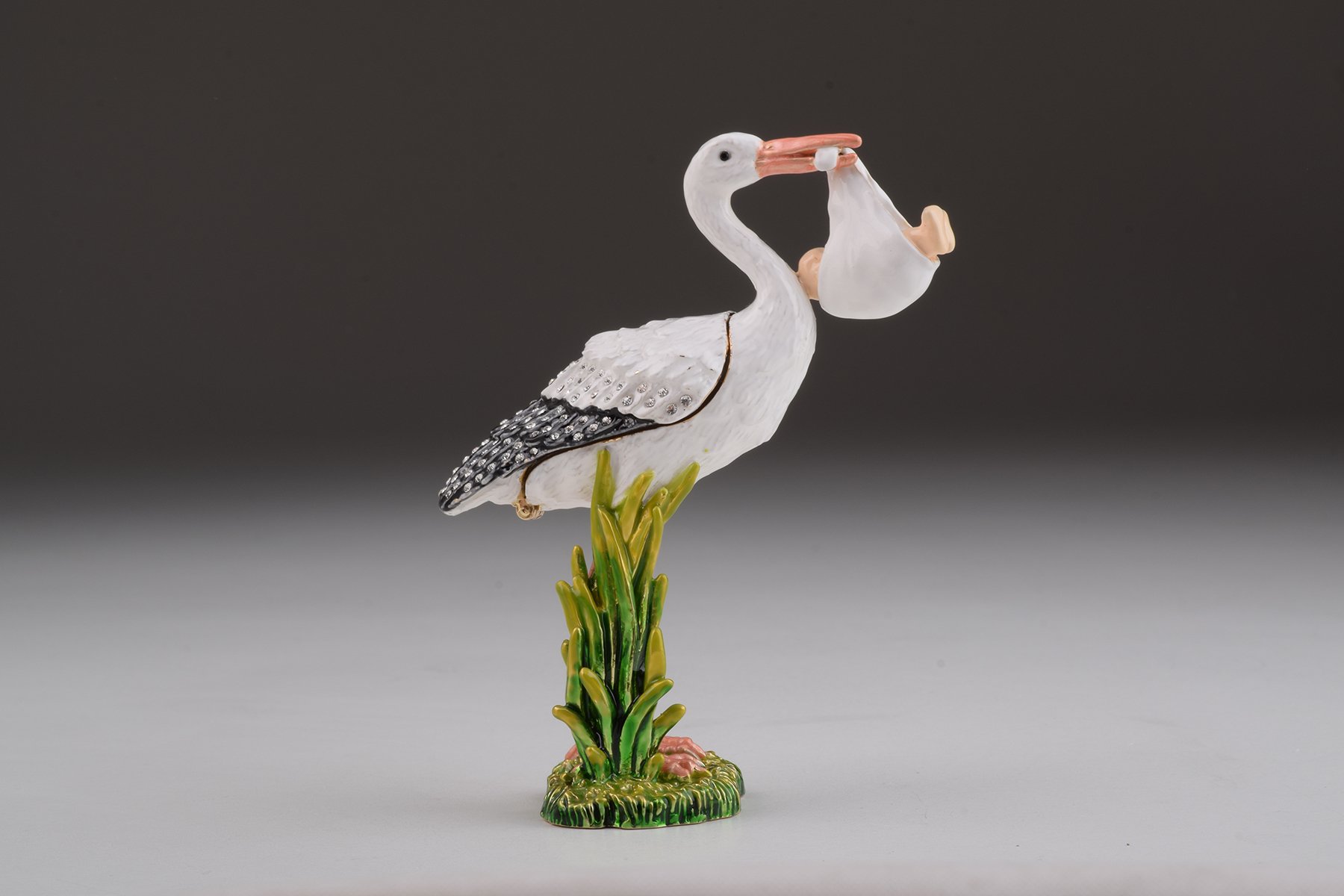 Handcrafted White Stork Carrying a Baby trinket box adorned with Austrian crystals and plated with 24K gold, showcasing exquisite craftsmanship.