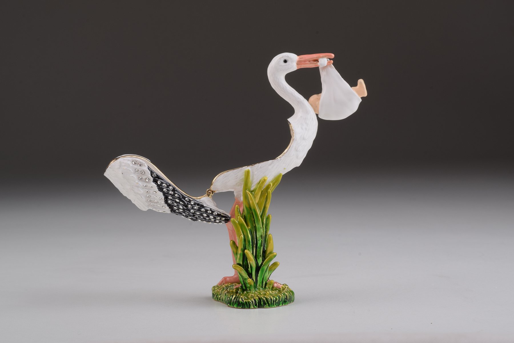 Handcrafted White Stork Carrying a Baby trinket box adorned with Austrian crystals and plated with 24K gold, showcasing exquisite craftsmanship.