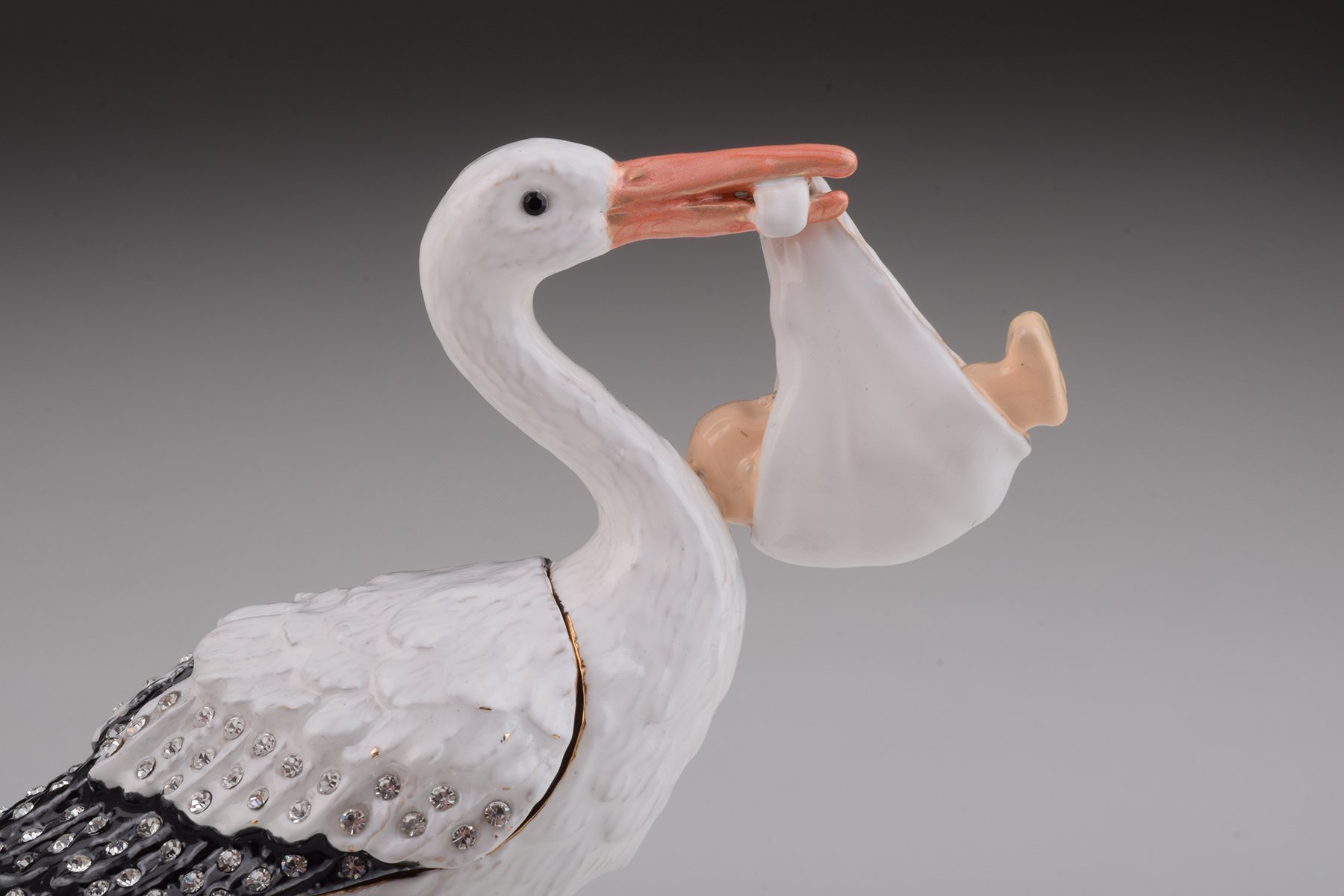 Handcrafted White Stork Carrying a Baby trinket box adorned with Austrian crystals and plated with 24K gold, showcasing exquisite craftsmanship.