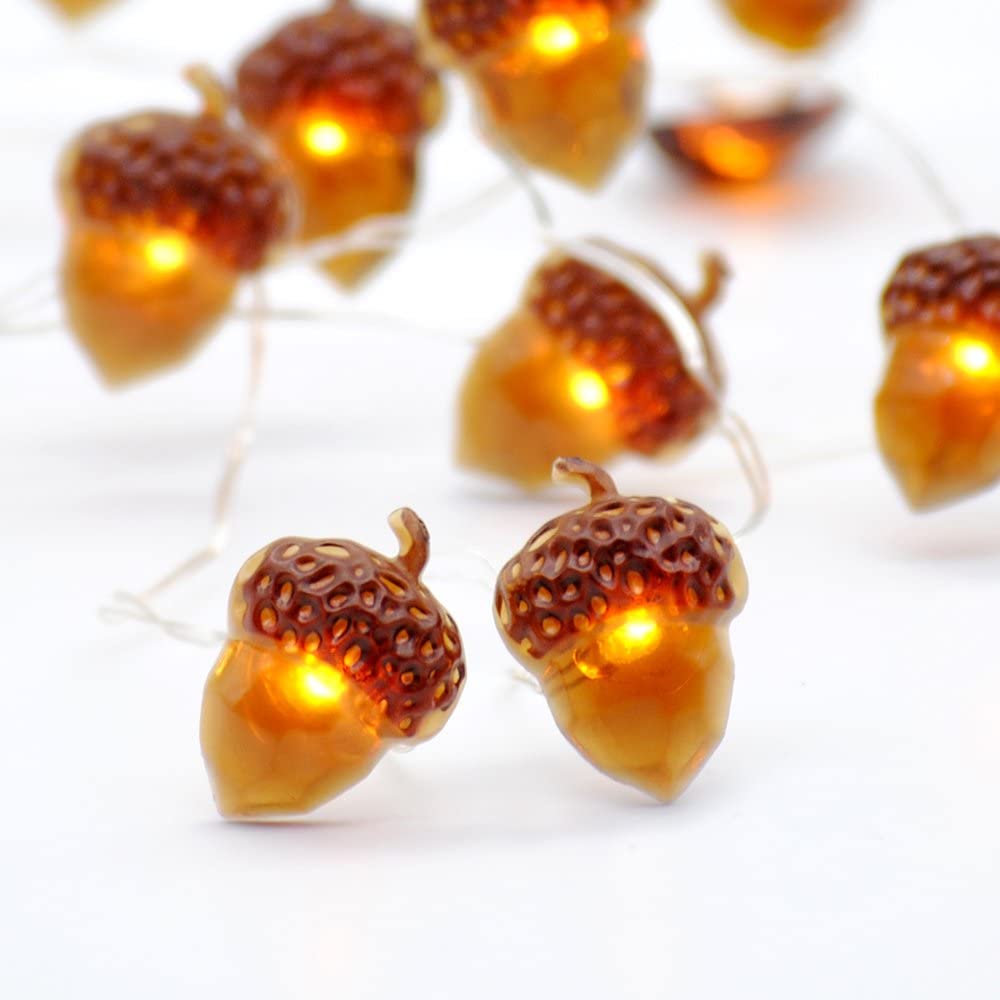 A string of battery-powered acorn-shaped LED lights, perfect for Thanksgiving and autumn decorations, showcasing a warm glow against a cozy backdrop.