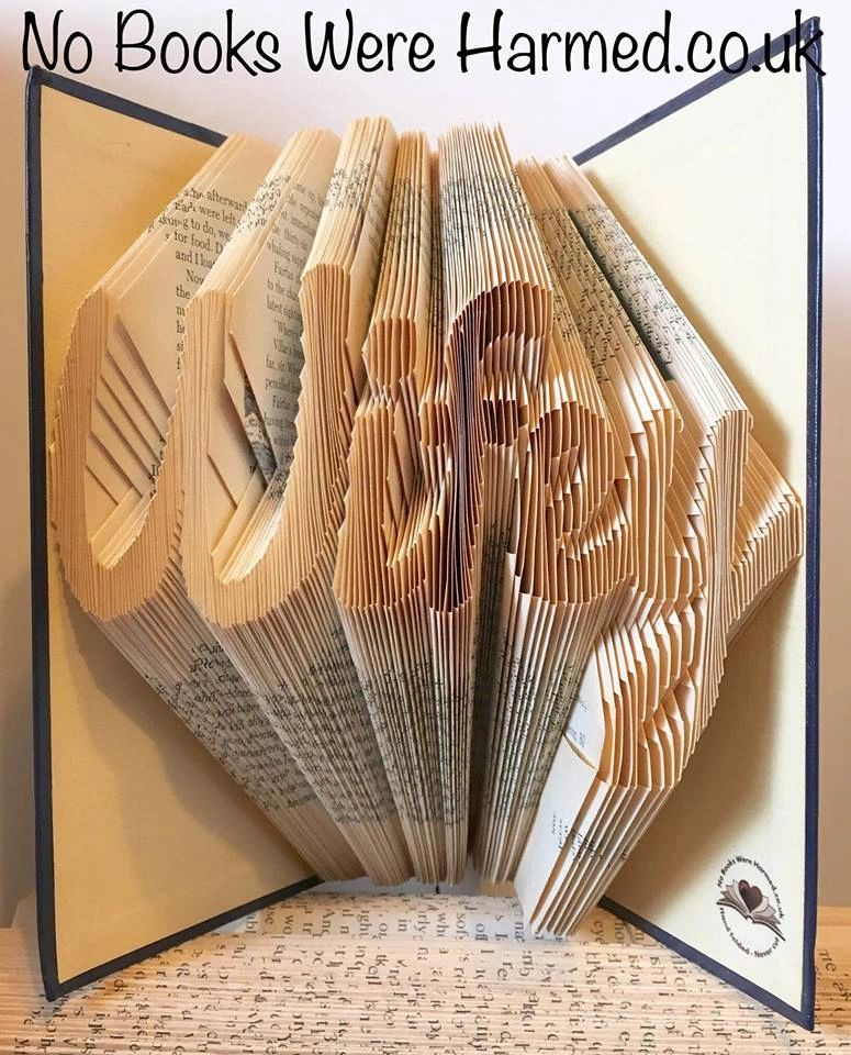 Handcrafted 'Wifey' book art made from vintage books, showcasing unique folds and colors.