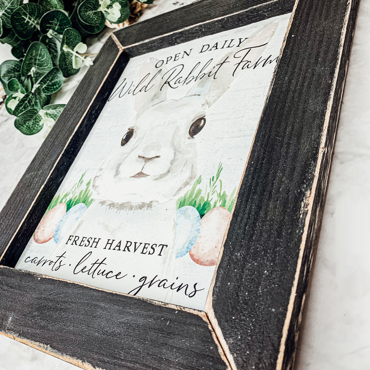 Wild Rabbit Farms Easter sign featuring a rustic design with pastel eggs and a hand-painted wooden frame.