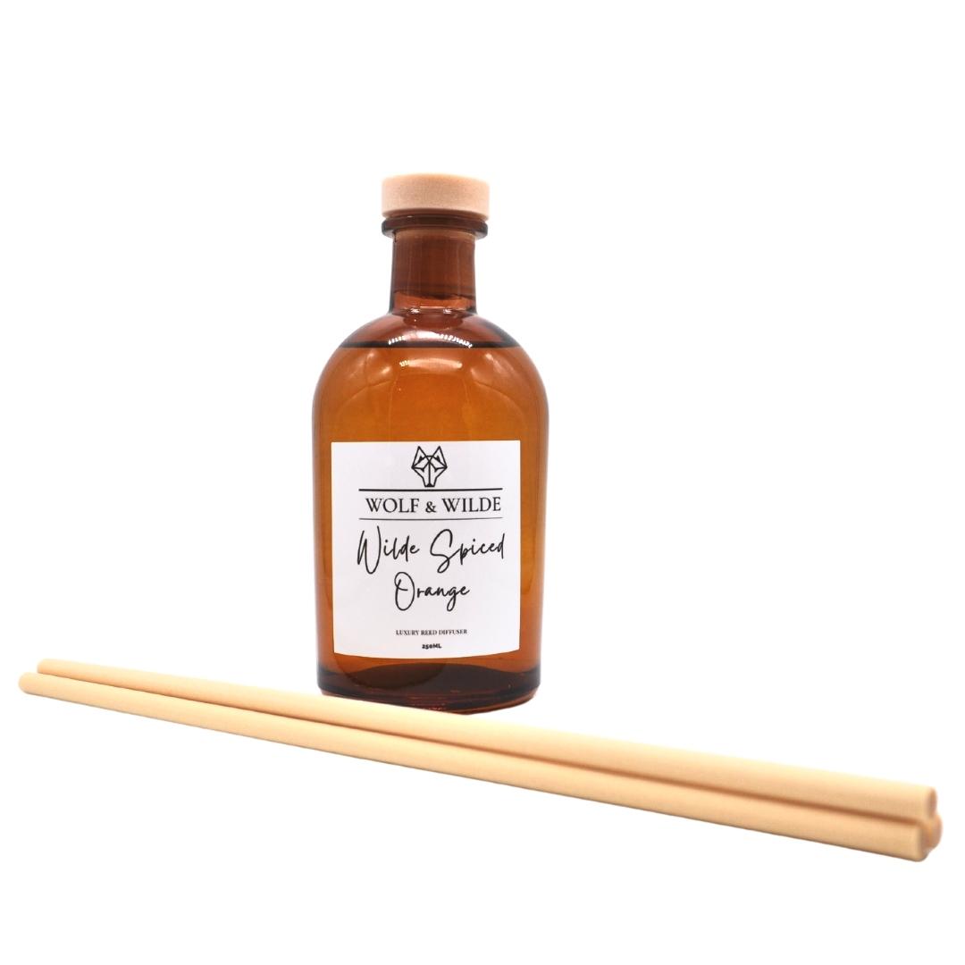 Wilde Spiced Orange Apothecary Reed Diffuser in an amber bottle with thick reeds, showcasing its elegant design and eco-friendly materials.