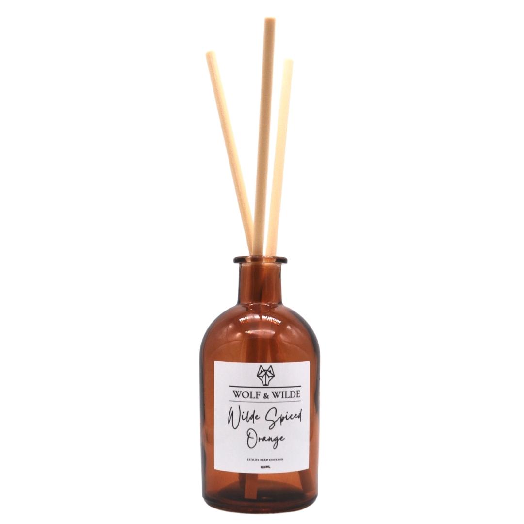 Wilde Spiced Orange Apothecary Reed Diffuser in an amber bottle with thick reeds, showcasing its elegant design and eco-friendly materials.