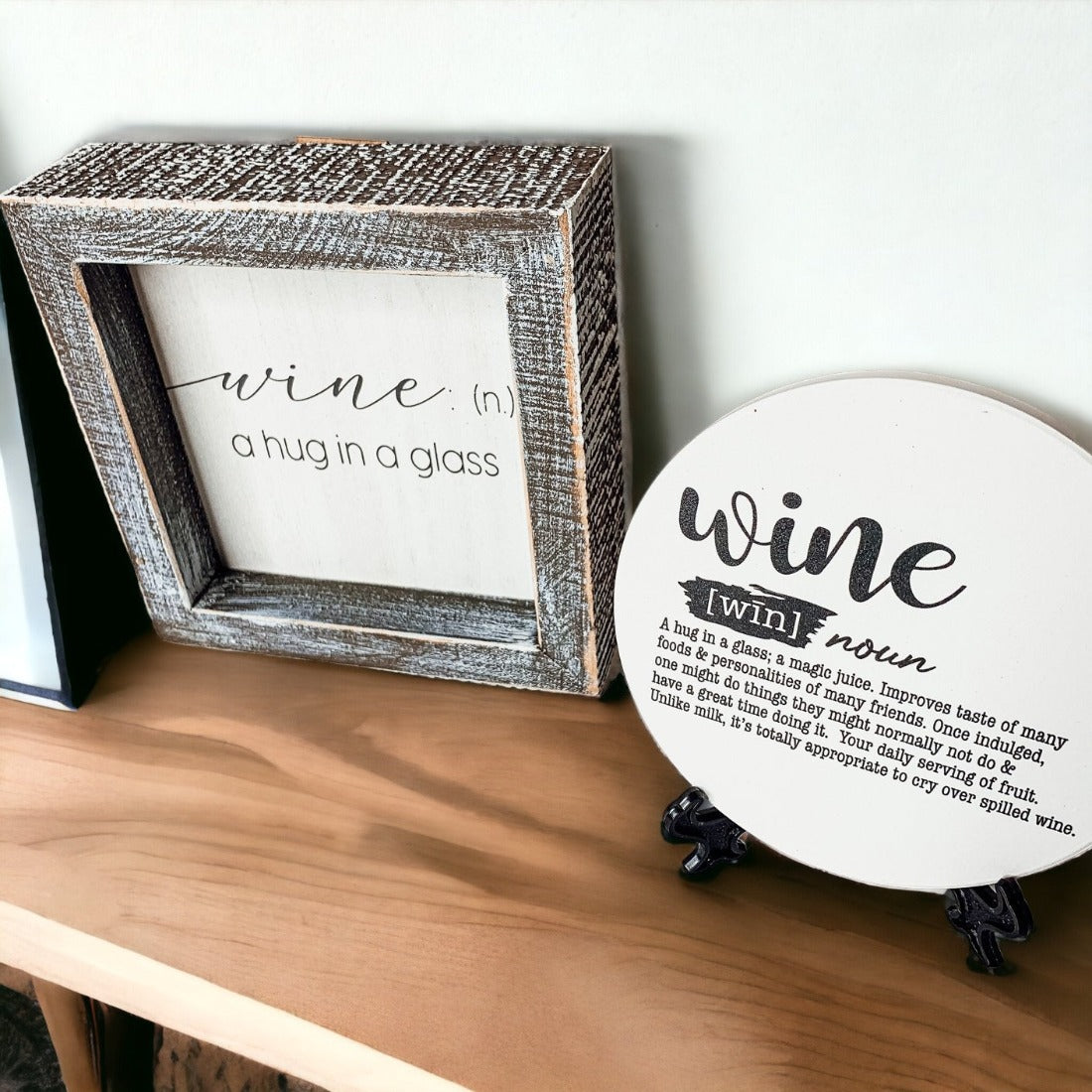 A beautifully framed wooden sign that reads 'Wine: A Hug', featuring a white-washed finish, perfect for home decor.