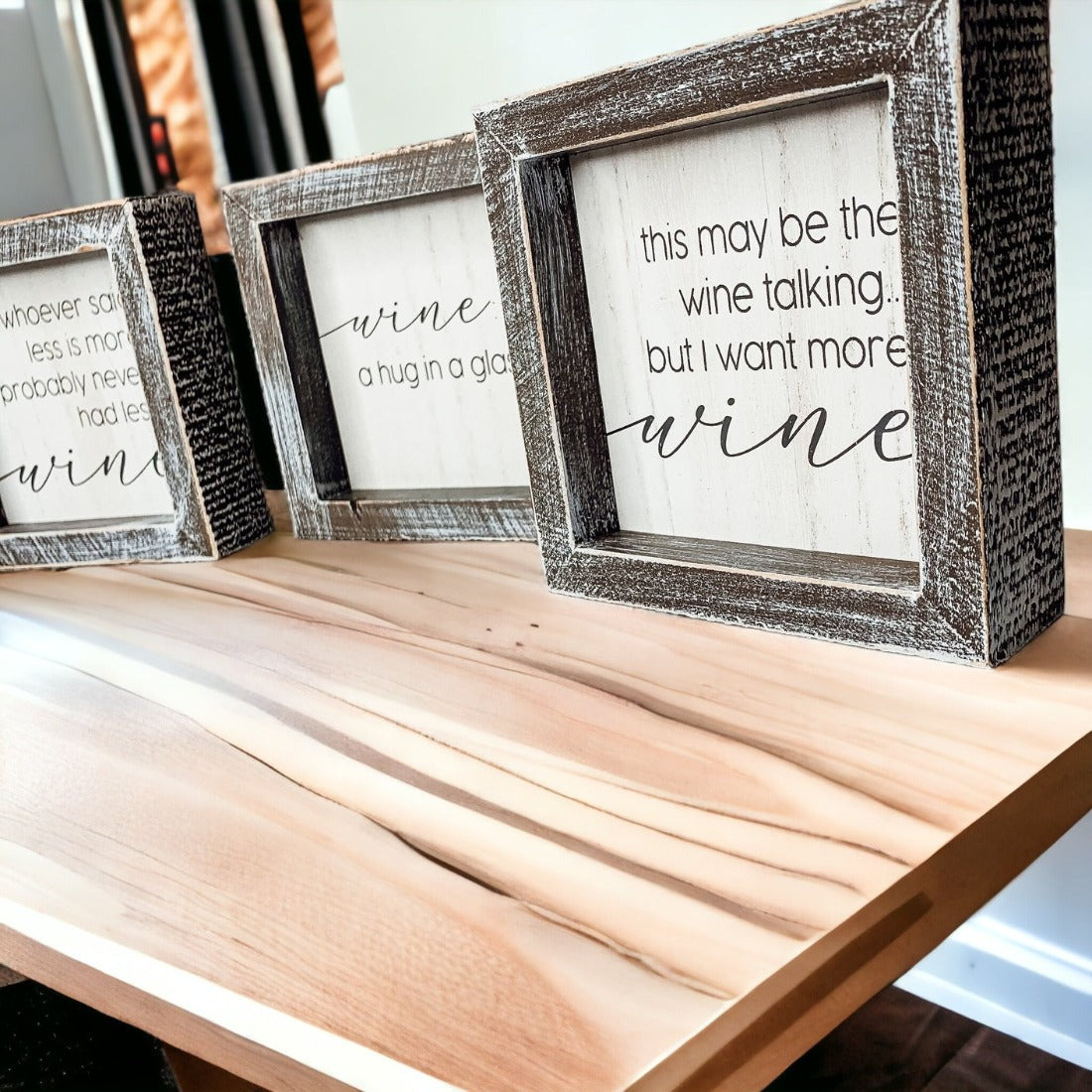 A beautifully framed wooden sign that reads 'Wine: A Hug', featuring a white-washed finish, perfect for home decor.