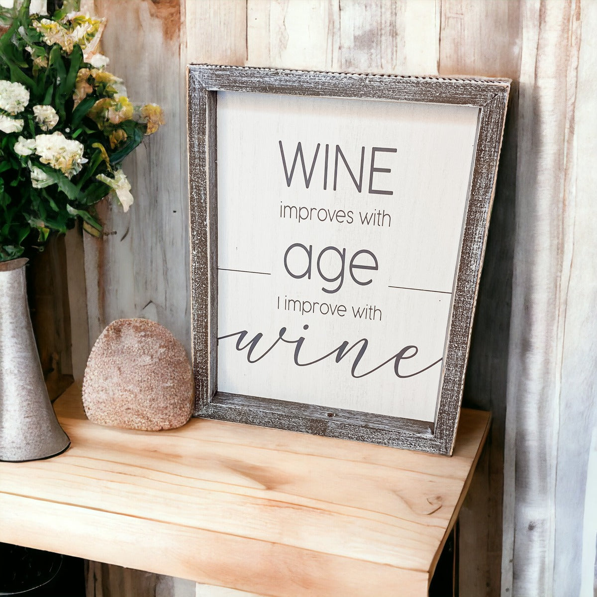 A stylish wood sign that reads 'Wine improves with age, I improve with wine', featuring a modern design in white and grey colors.