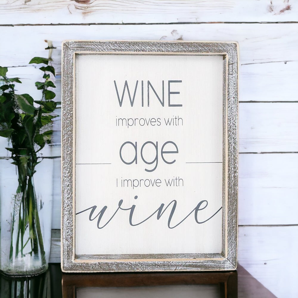 A stylish wood sign that reads 'Wine improves with age, I improve with wine', featuring a modern design in white and grey colors.