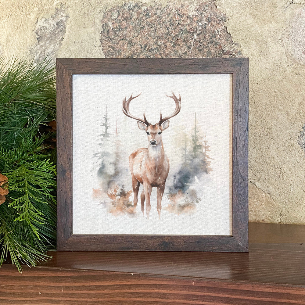 Framed sign featuring a winter buck scene with a walnut veneer frame and linen-look background.