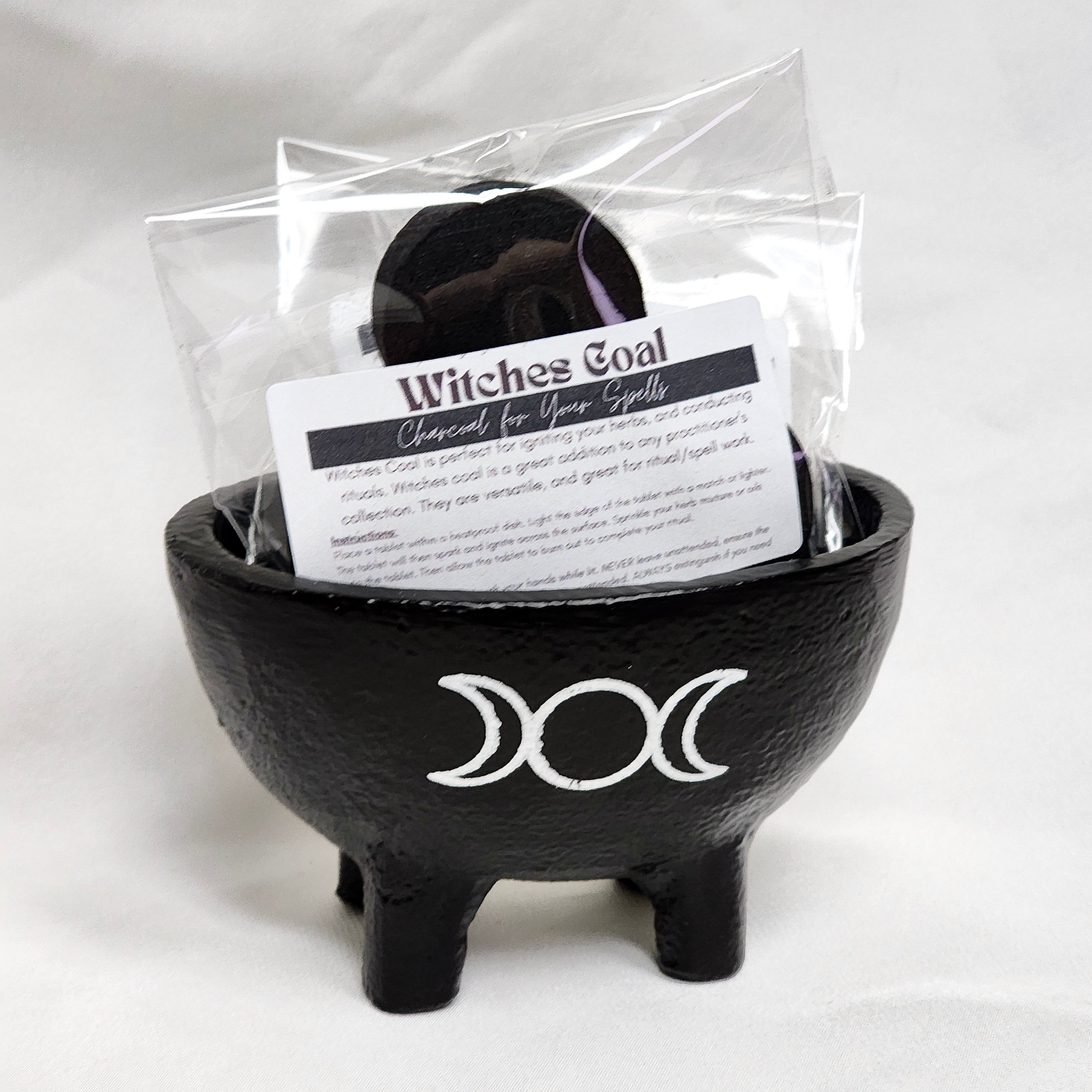 Three pieces of Witches Coal, activated charcoal for rituals, displayed on a wooden surface, ideal for igniting herbs.