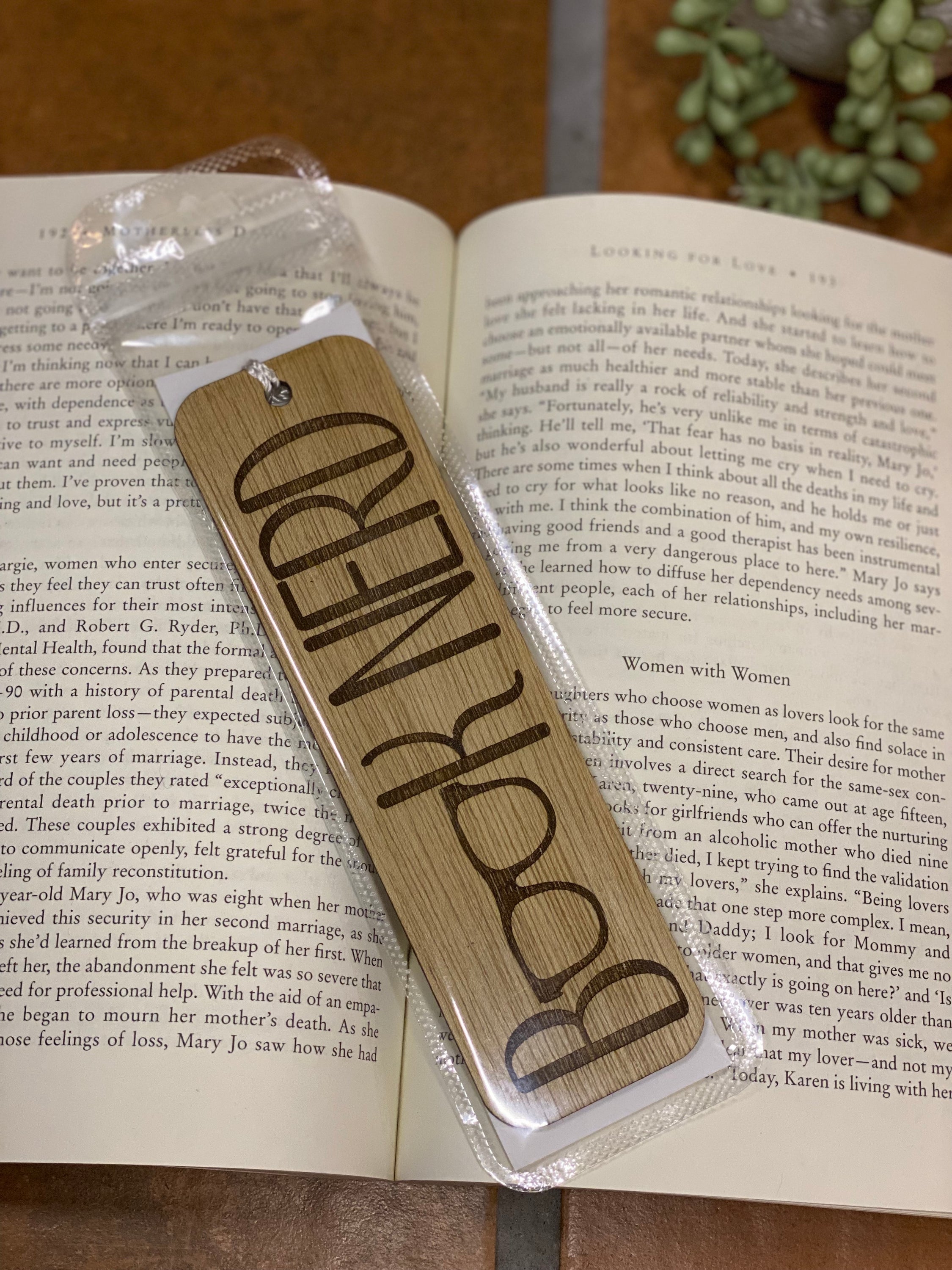 A beautifully crafted wooden bookmark with a white tassel, showcasing unique laser engraved designs.