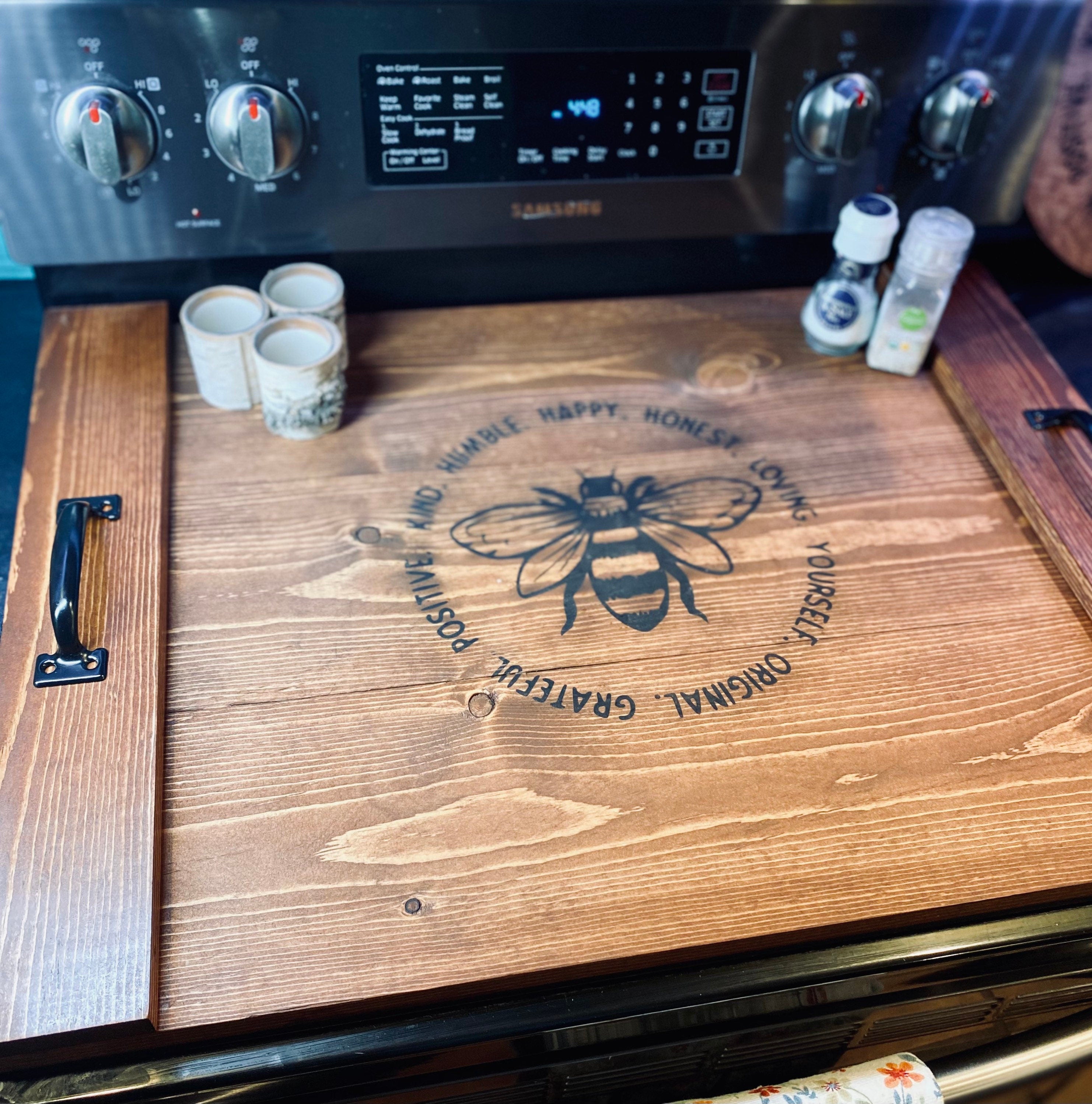 Handmade wooden stove cover in dark chestnut stain, designed for flat top electric stoves, featuring black metal handles.