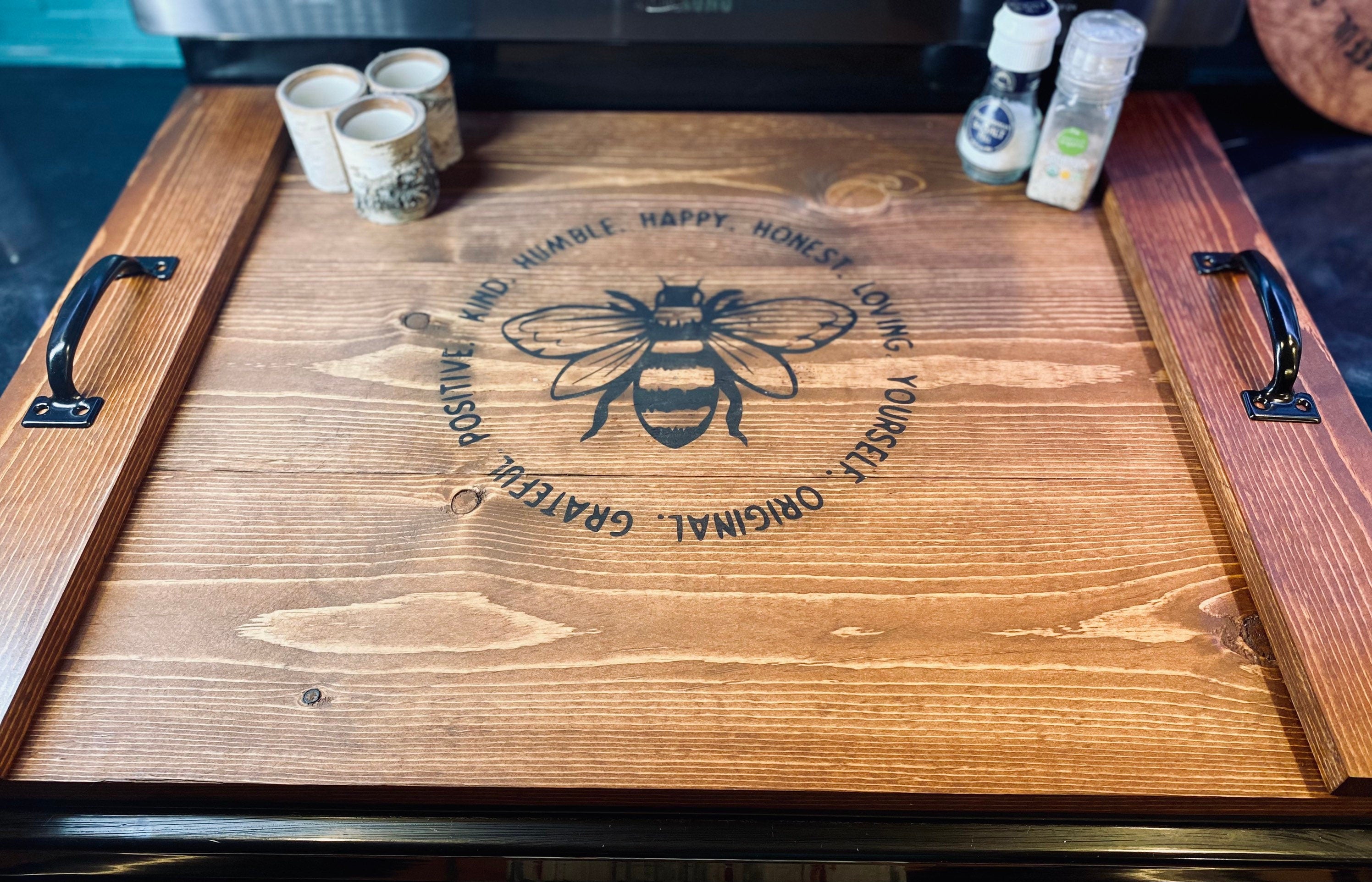 Handmade wooden stove cover in dark chestnut stain, designed for flat top electric stoves, featuring black metal handles.