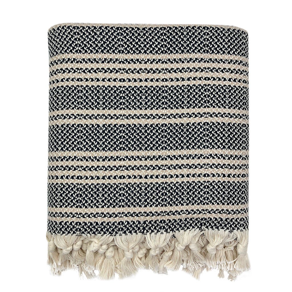 A cozy Woven Stripe Turkish Throw featuring intricate stripe patterns and hand-knotted fringe, perfect for home decor.