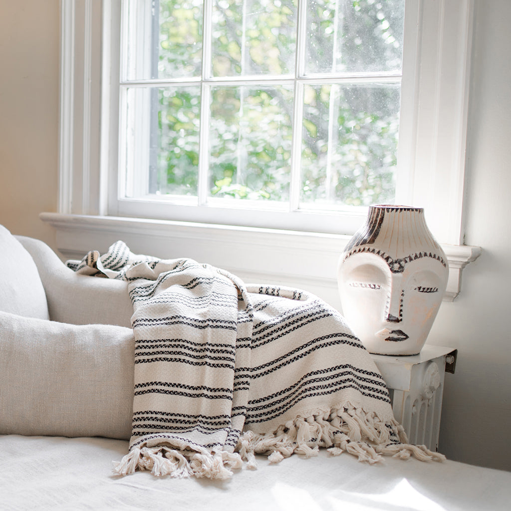 A cozy Woven Stripe Turkish Throw featuring intricate stripe patterns and hand-knotted fringe, perfect for home decor.